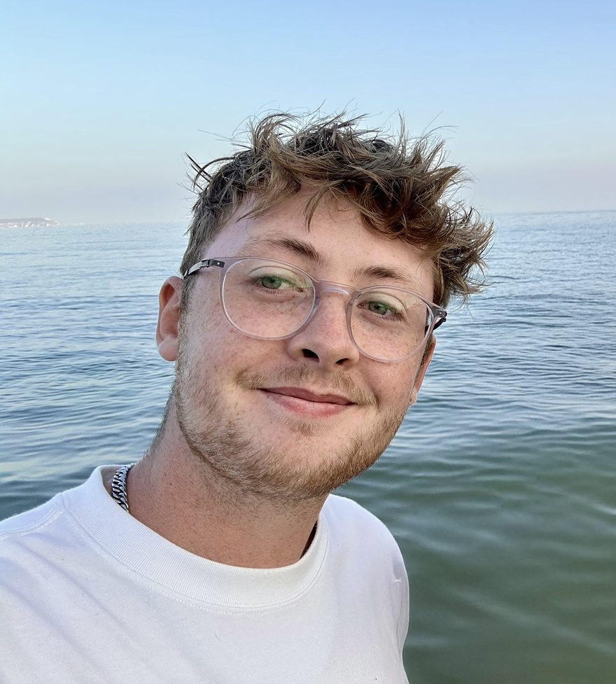 James Ingram, smiling, by the sea in Bournemouth
